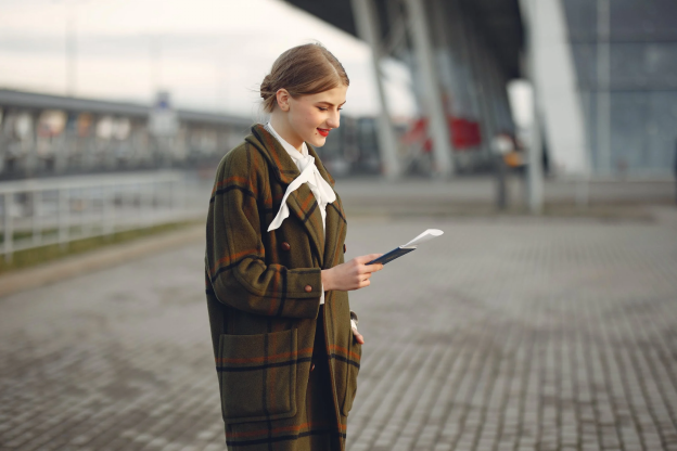 A photo showing a woman holding a passport outdoors.