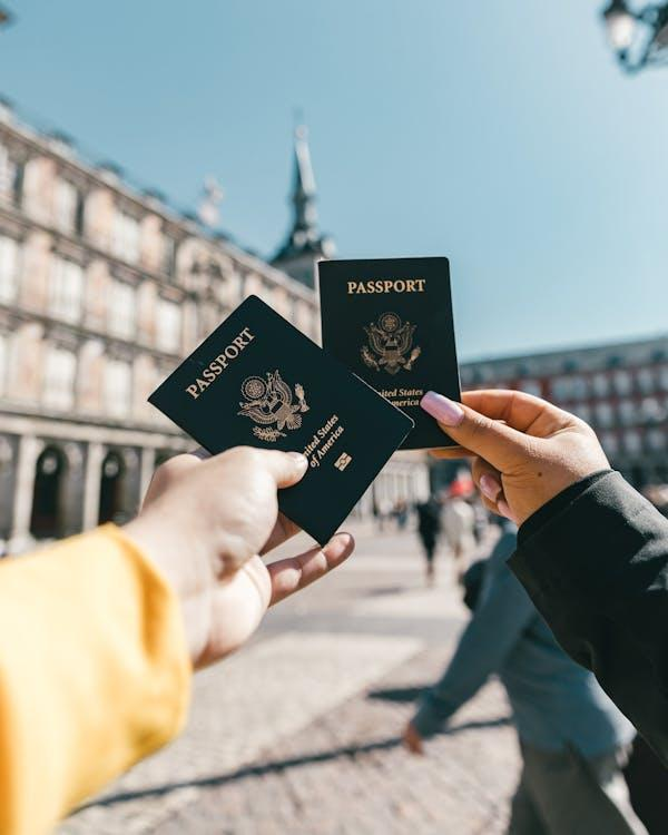 Tourists showing their U.S. passports on a sunny day, ready for international travel.