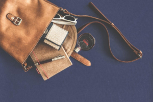 A brown leather crossbody bag paired with white-framed sunglasses, perfect for stylish, secure travel.