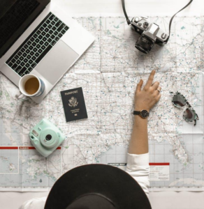 A person pointing at a location on a map, symbolizing travel planning and navigation.