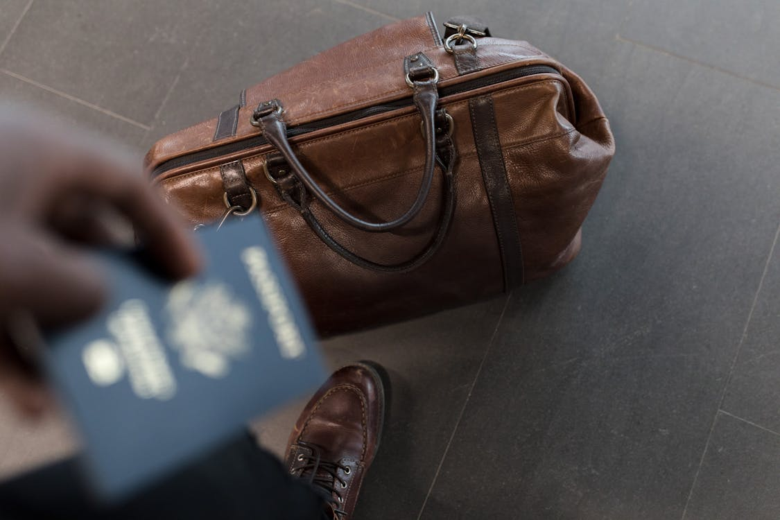 A person with a passport and duffel bag 