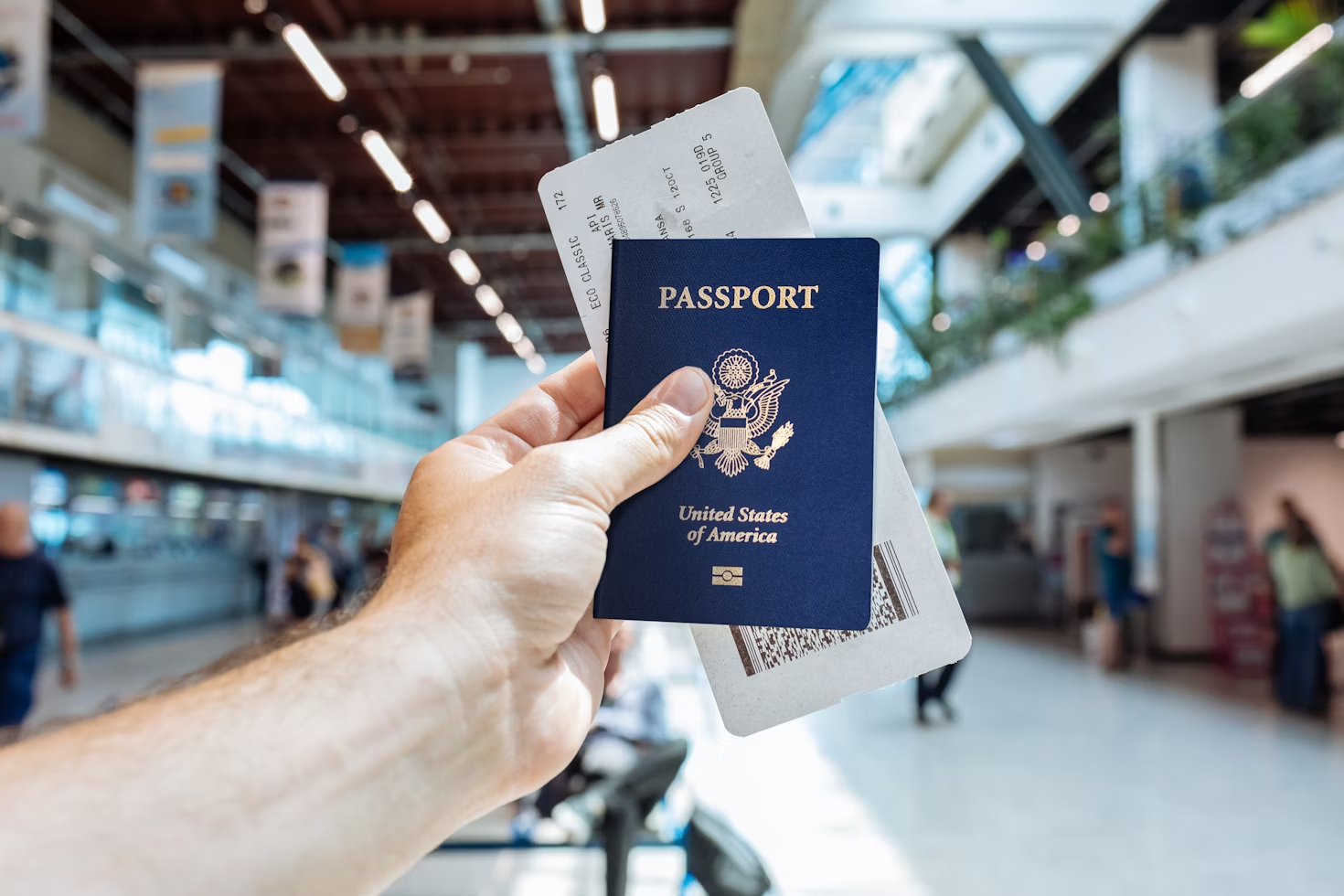 A man holding a passport and ticket