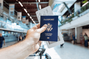A man holding a passport and ticket